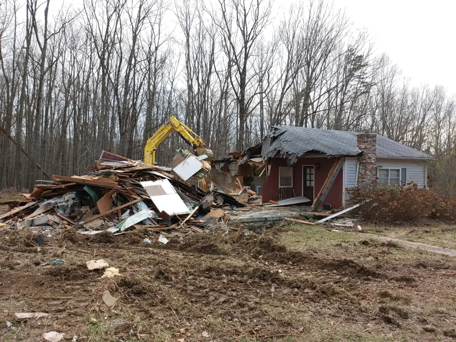 Excavator demolishing a house
